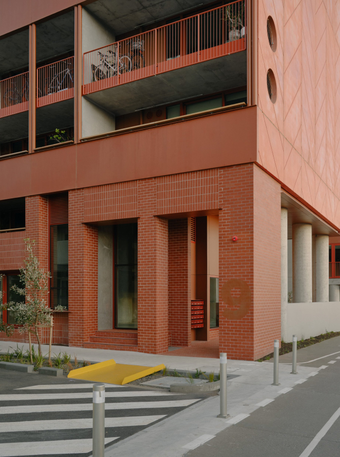 a street view of the entrance to a red brick apartment building