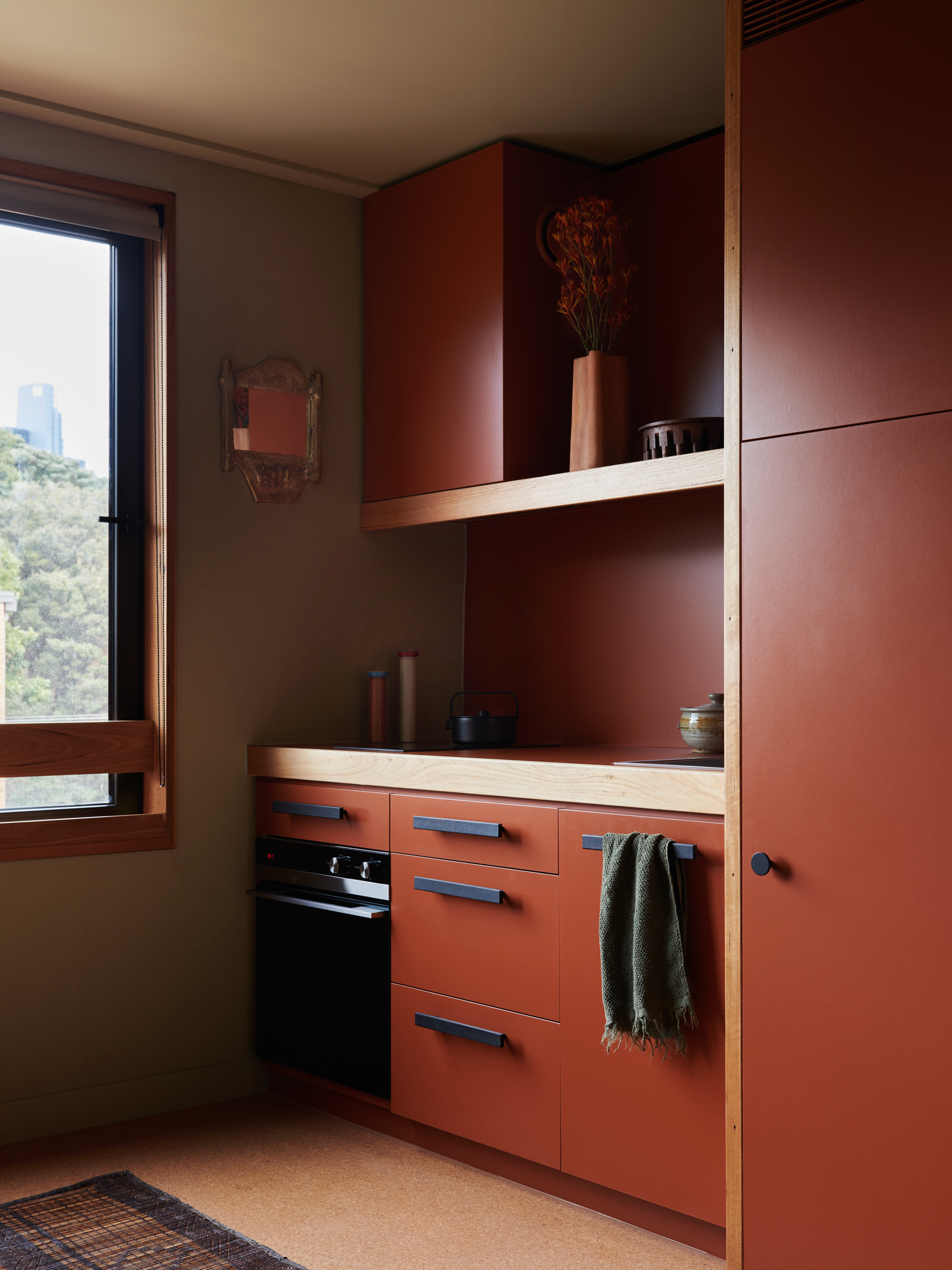 a kitchen with dark red cabinetry.