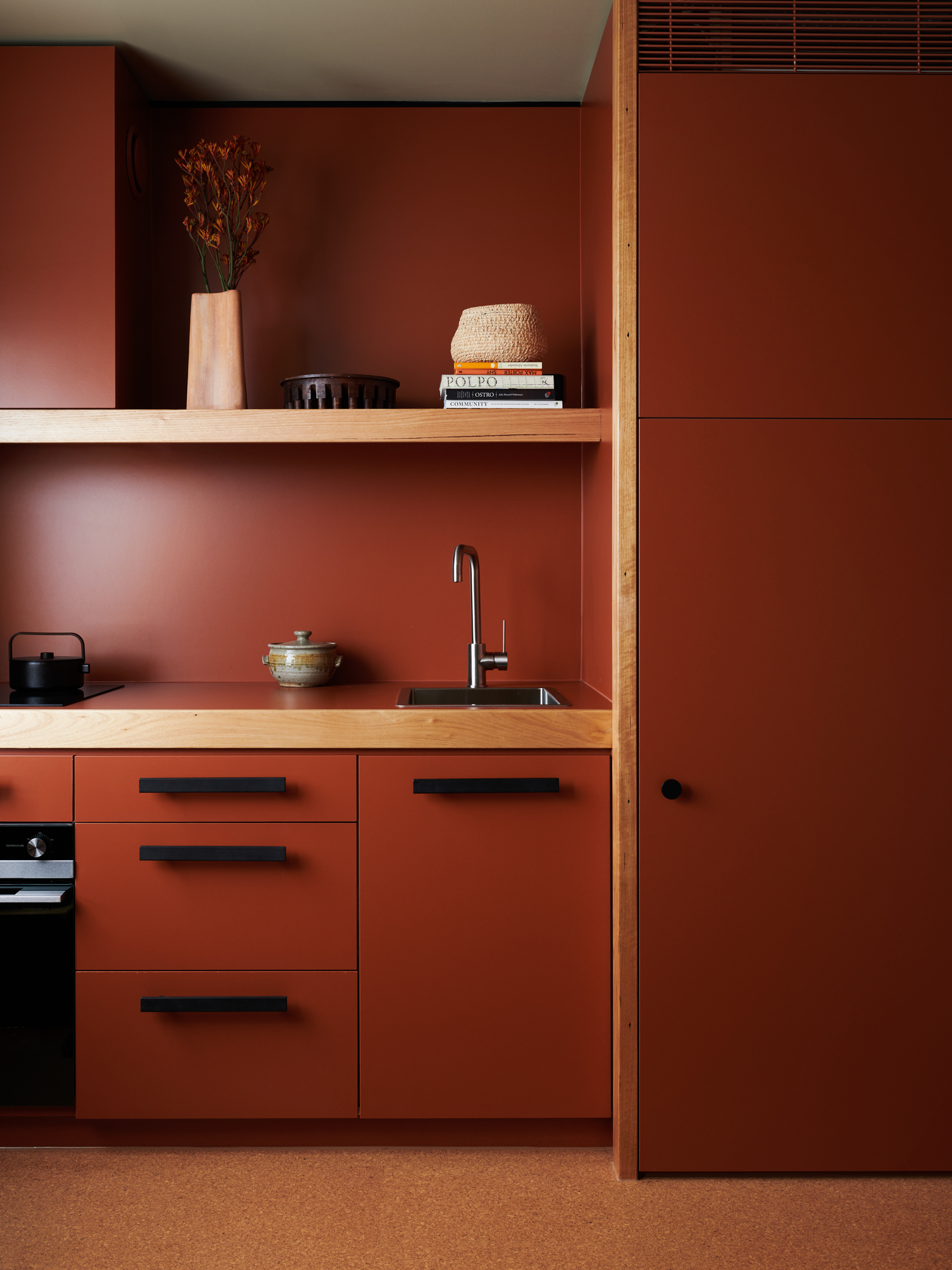 a deep red kitchen with a large cabinet and a sink